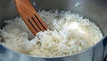 An image of rice being cooked using boiling method